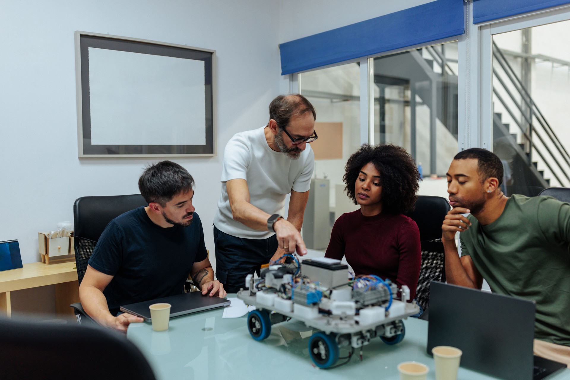 Robotics engineers analyzing a prototype in the office meeting room